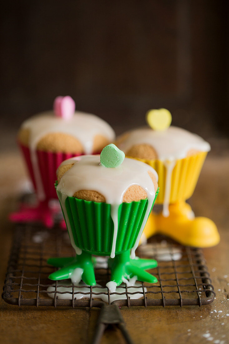 Zitronenmuffins mit Glasur in bunten Plastikformen mit Beinen