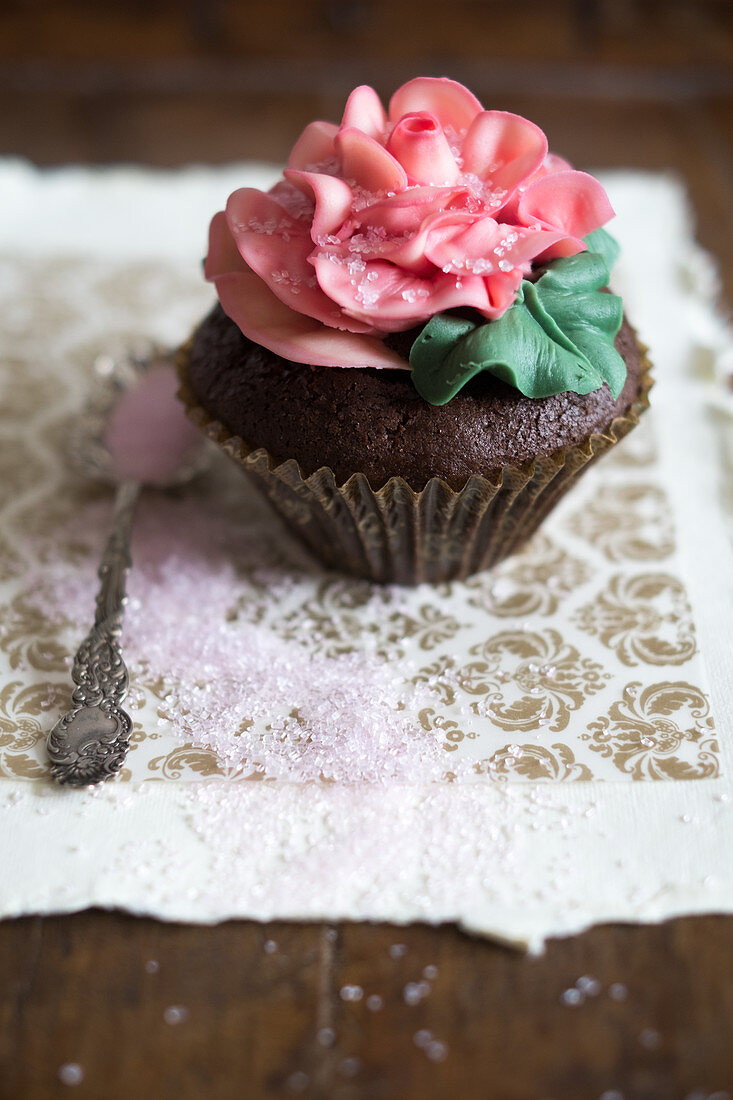 A cupcake decorated with a large sugar rose