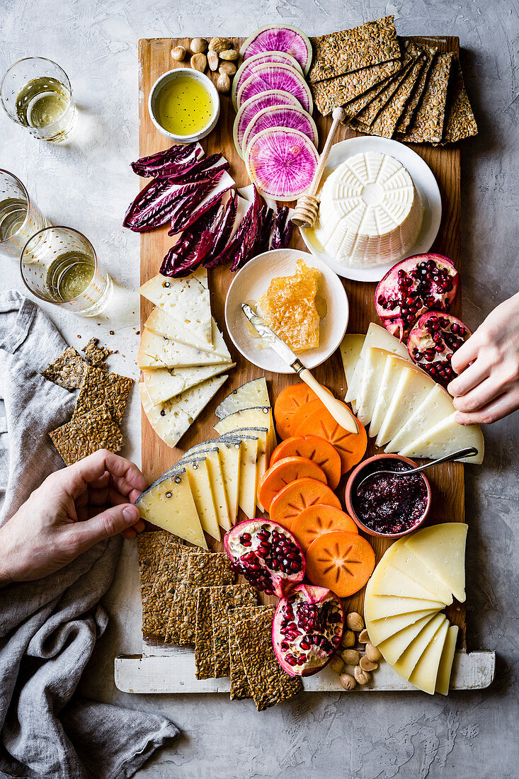 Käseplatte mit Gemüse, Obst, Crackern und Honig