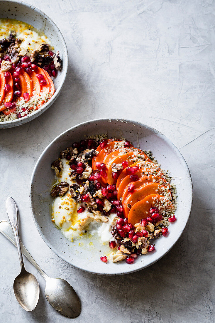 A yoghurt bowl with persimmons, pomegranate and walnuts