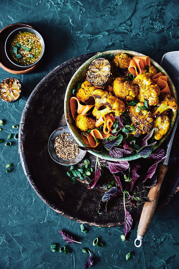 Roasted cauliflower coated in an Asian inspired turmeric, lemongrass and shallot marinade, mixed with a salad of asian greens, thin sliced cooked sweet potatoes, shallots and toast sesame seeds