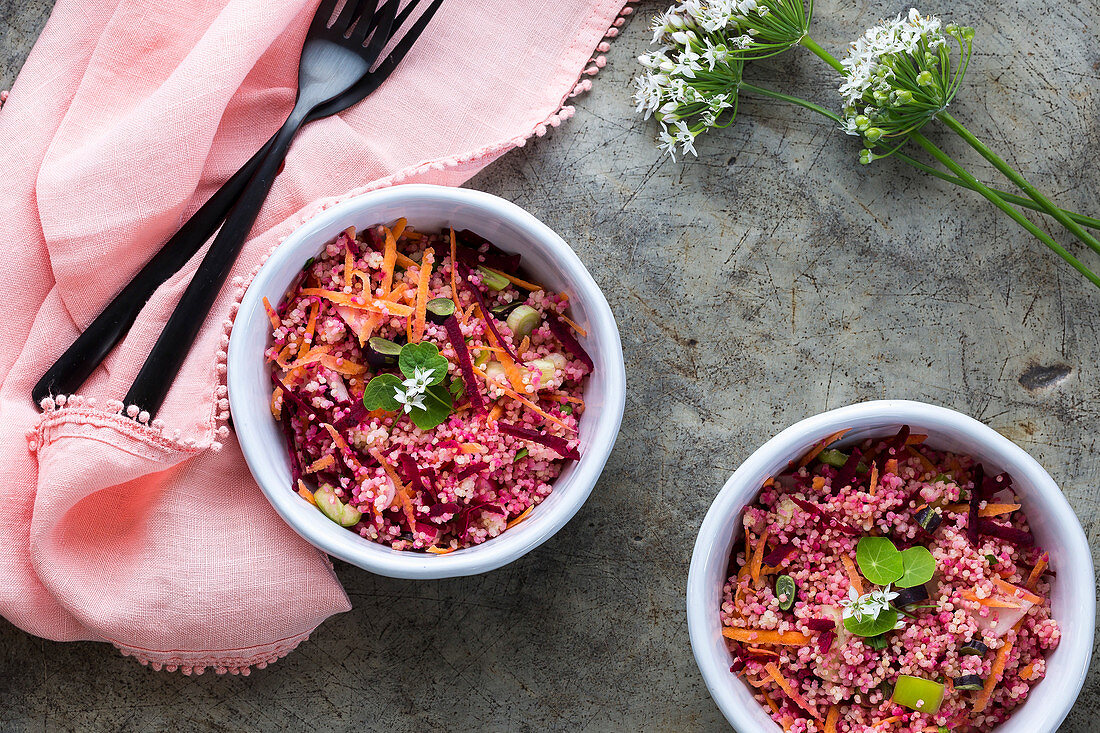 Roter und rosafarbener Hirsesalat mit Gemüse in Schälchen