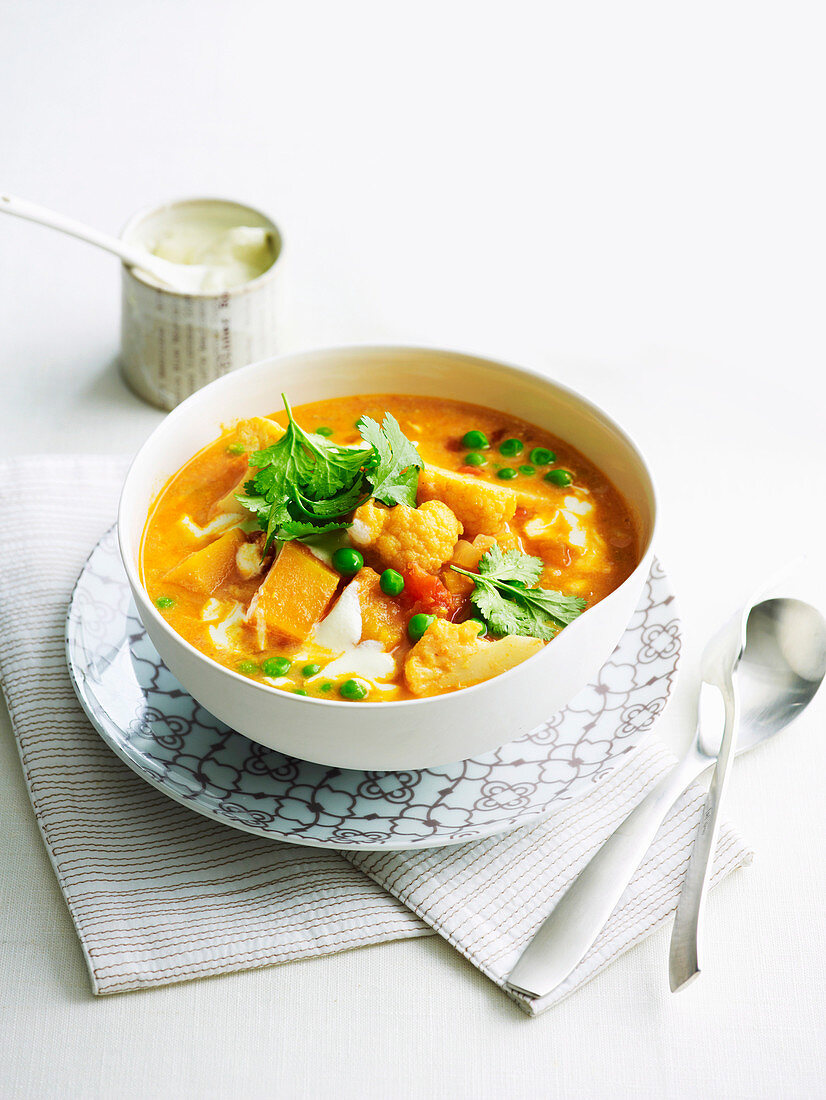 Cauliflower and pumpkin soup with peas and coriander
