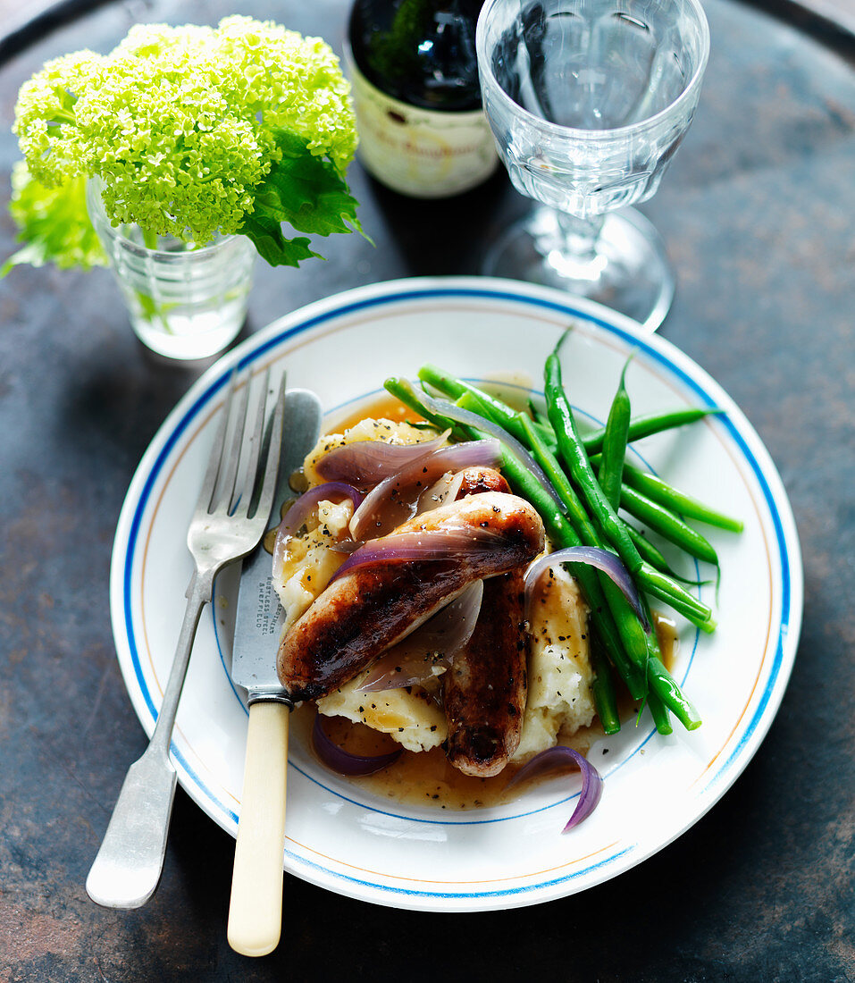 Sausages with mashed potatoes, green beans and red onions