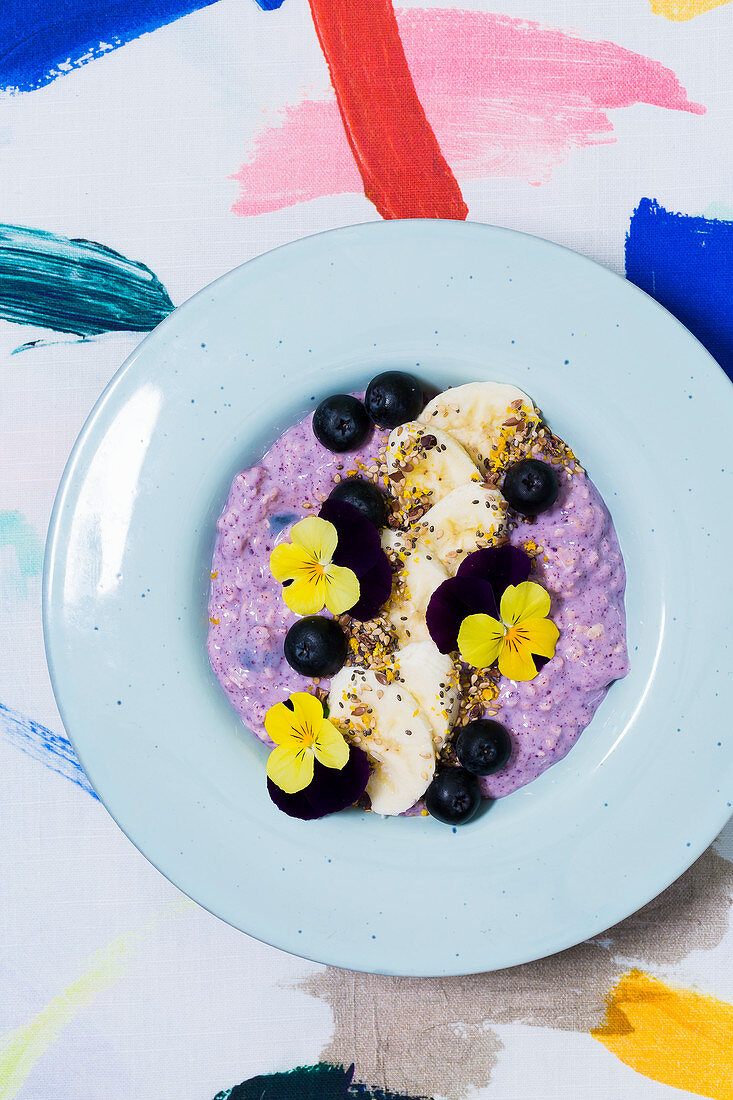 A blueberry and acai bowl with edible flowers