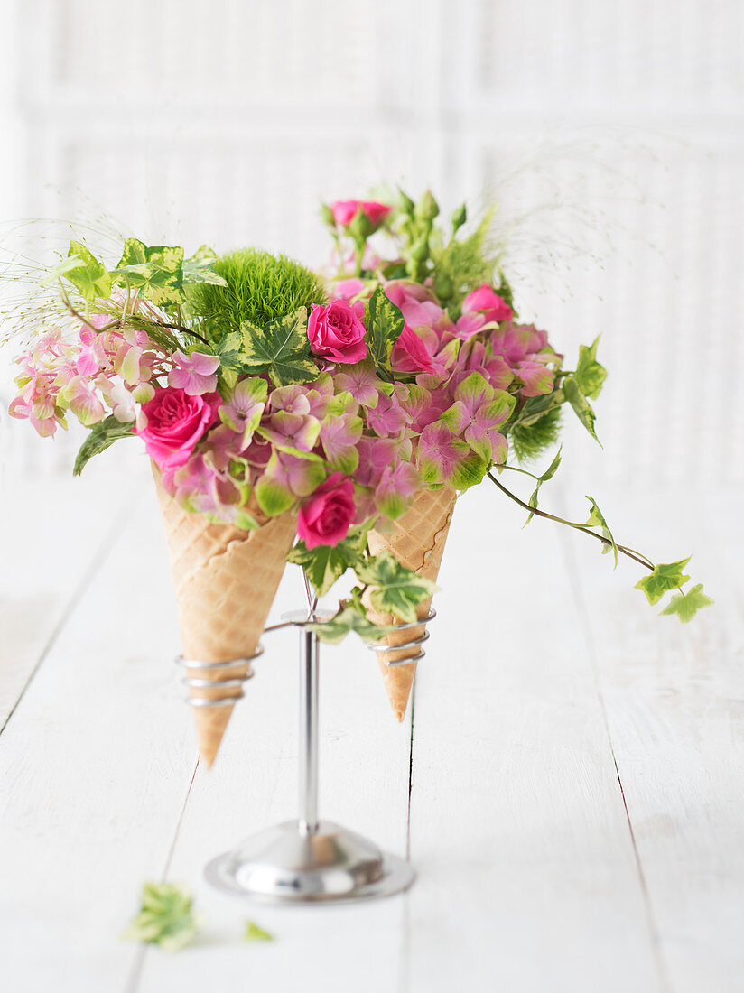 Gestecke mit Rosen und Hortensien in Eistüten