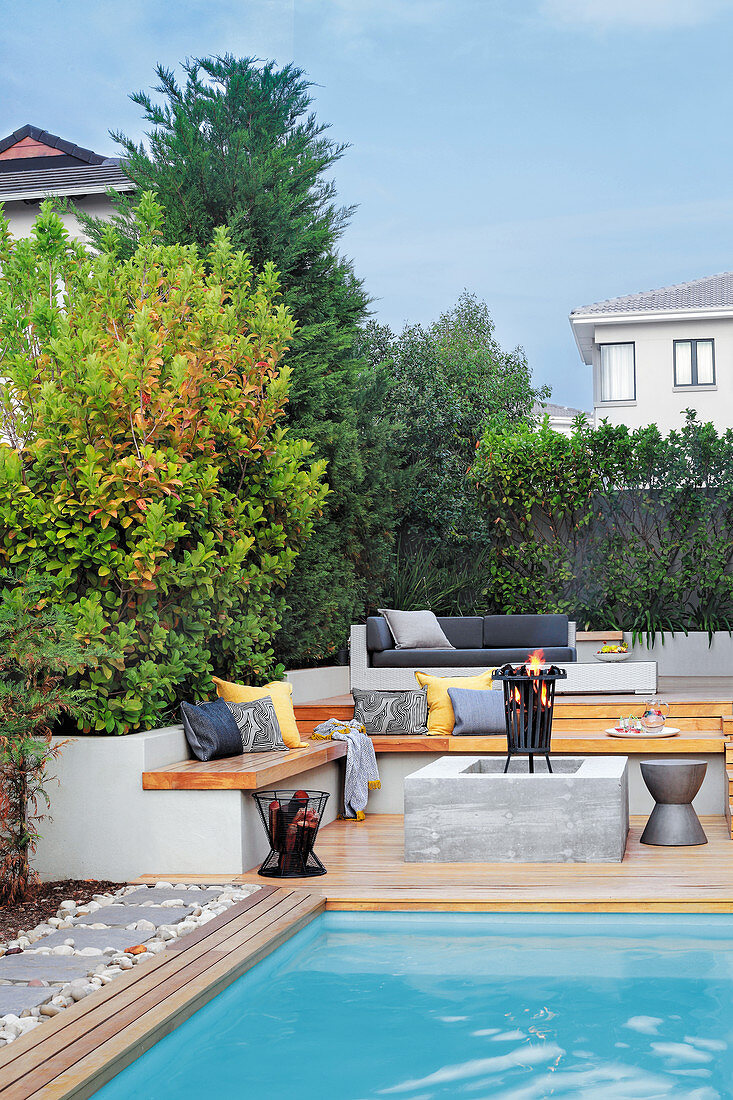 Masonry benches with wooden seats next to swimming pool