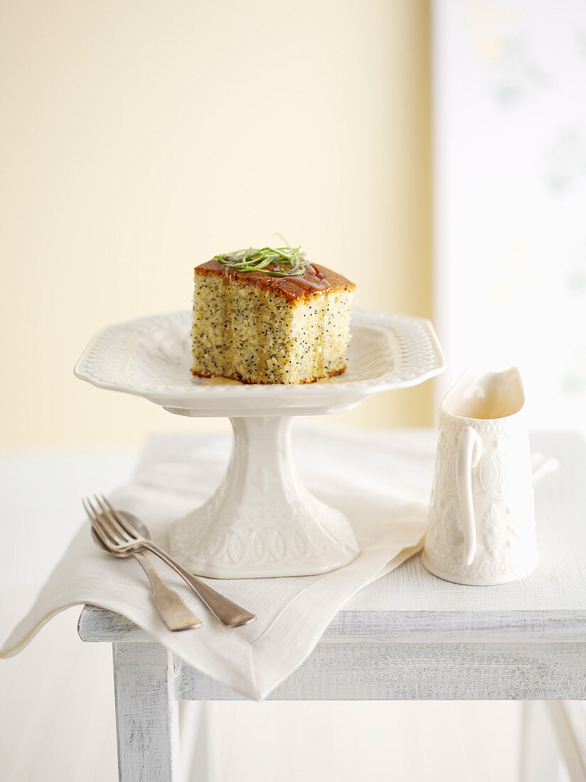 Limetten-Mohnkuchen, ein Stück auf Kuchenständer