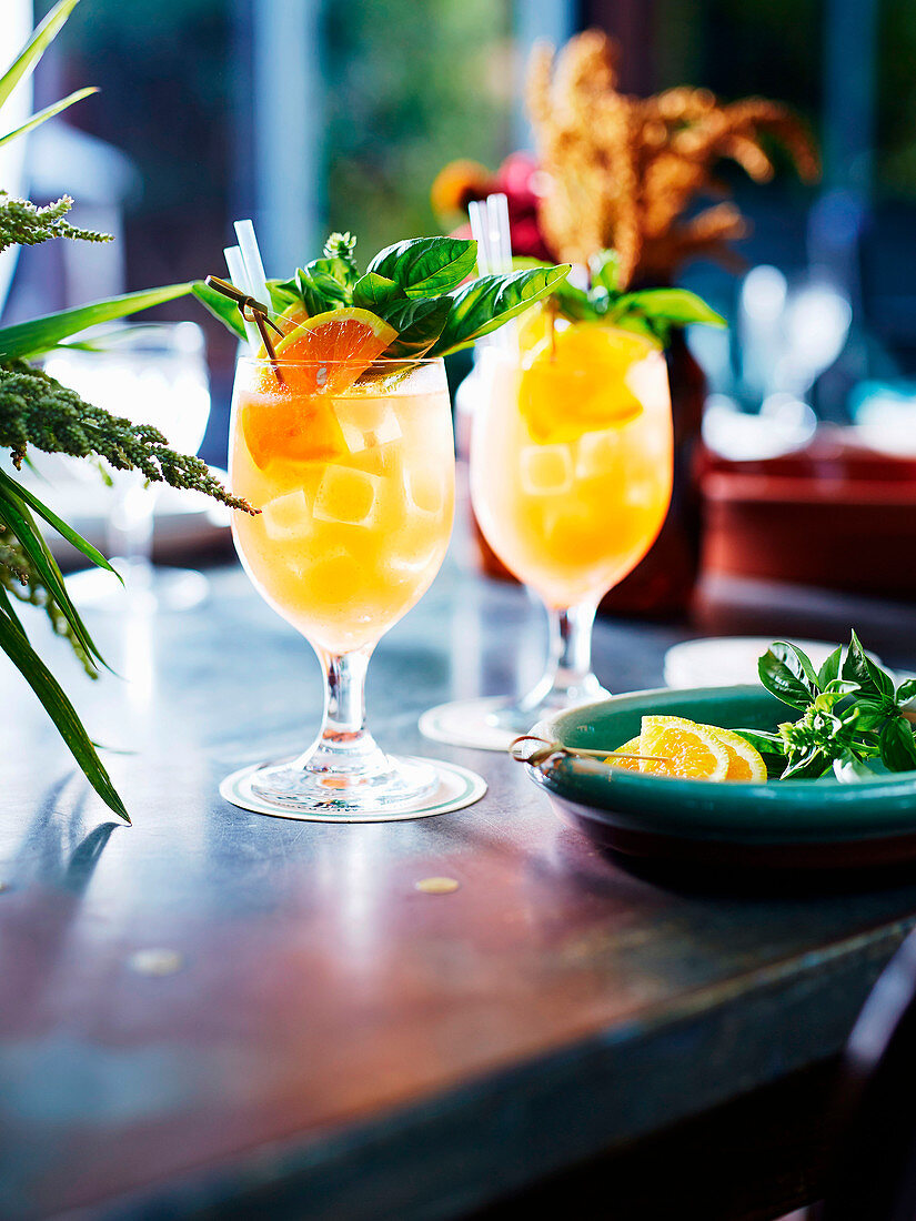 Zwei Pimms Cocktails mit Orange und Basilikum
