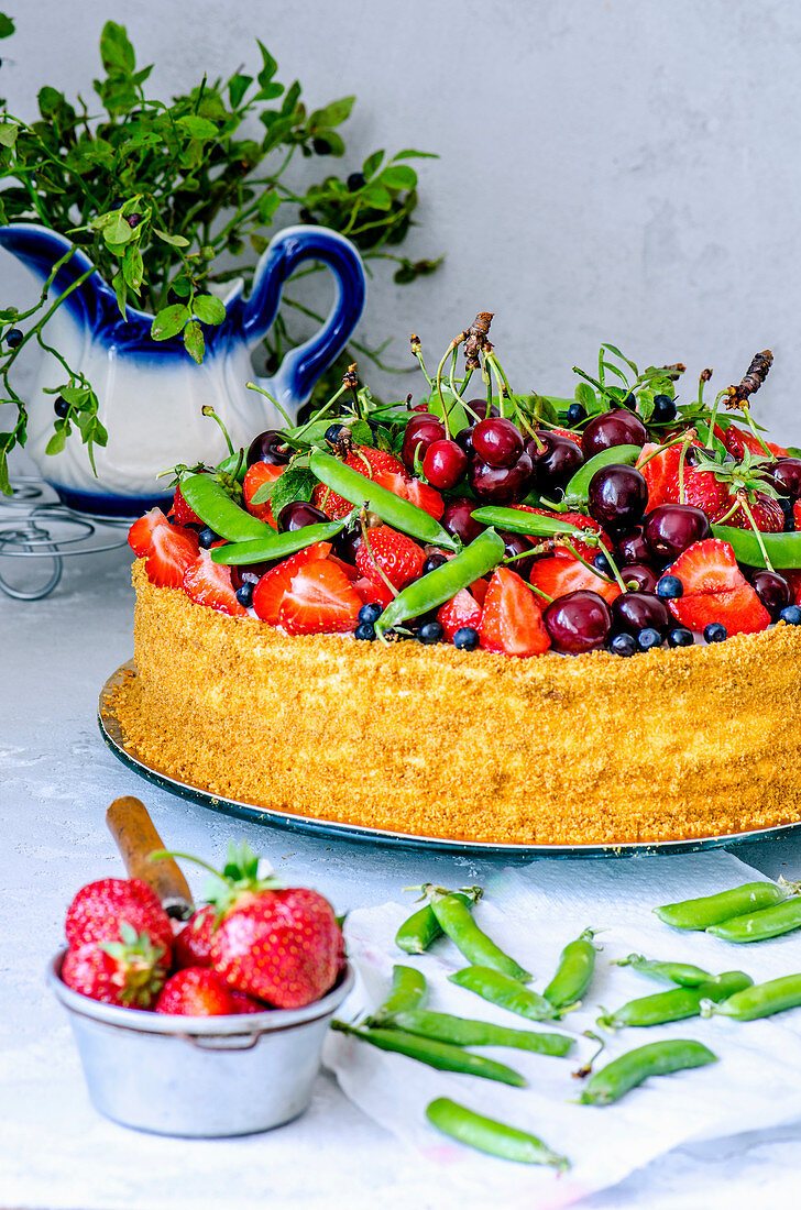 A fruit cake with strawberries, cherries, pea pods and blueberries
