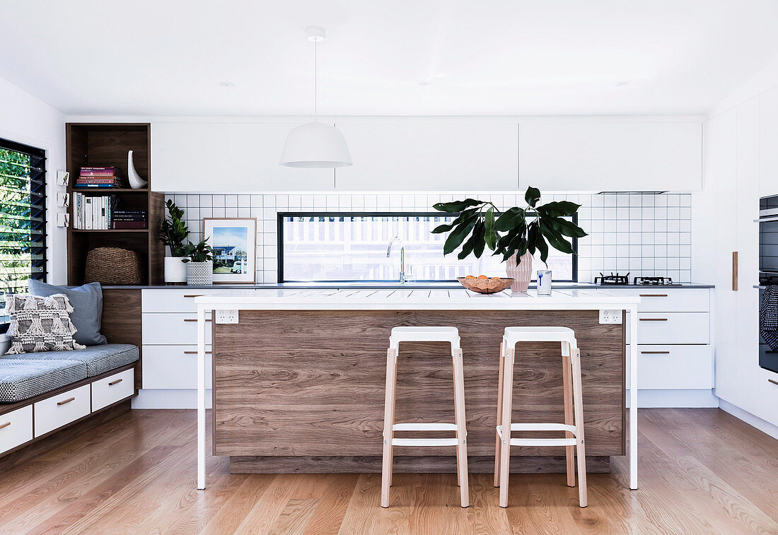 Open kitchen with kitchen island and bar stools, side bench with overlay and drawer