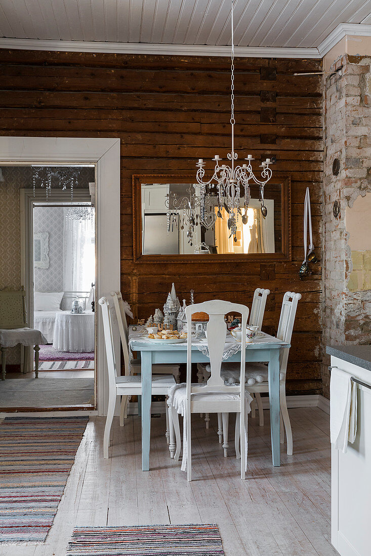 Set table and chairs below chandelier decorated with old silver cutlery