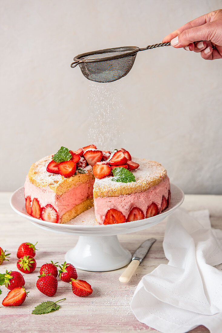 Erdbeermoussetorte mit Puderzucker, angeschnitten