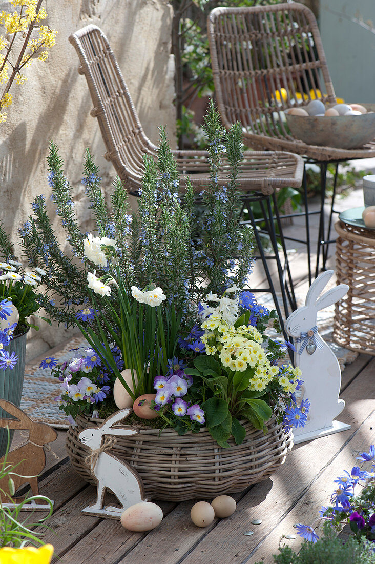 Terrace arrangement with rosemary and spring flowers in a basket