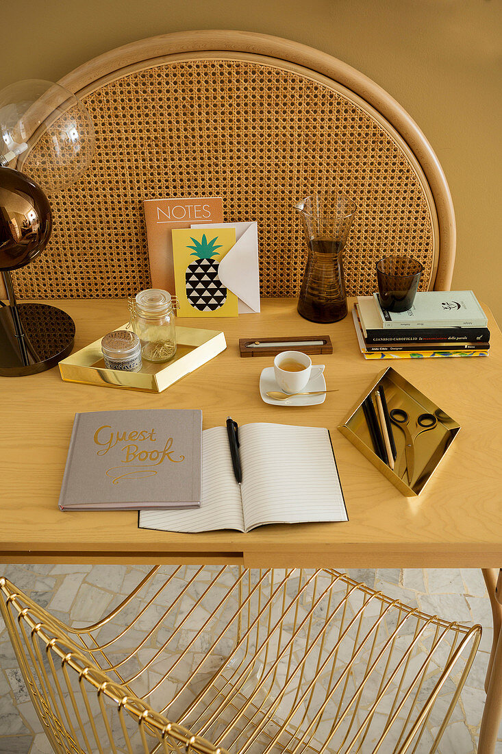 Writing utensils, books and cup of tea on table