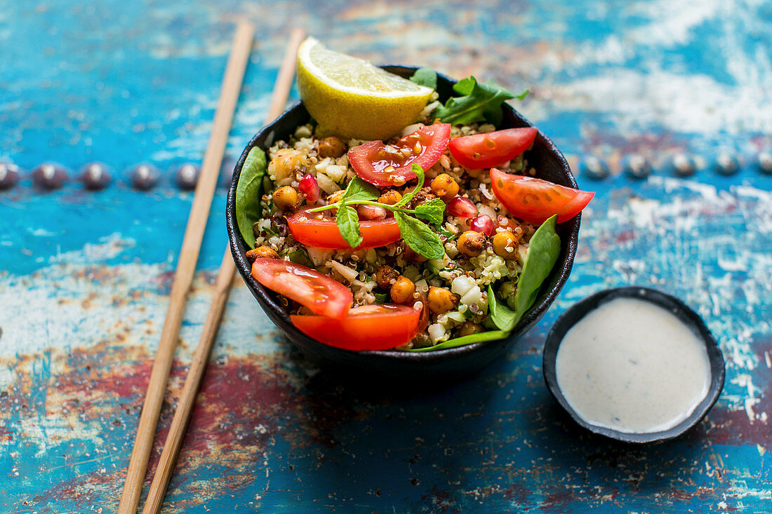 Quinoa salad with cauliflower, chickpeas, spinach, tomatoes and yoghurt