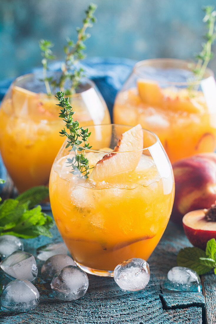 Peach cocktail or tea with ice and thyme