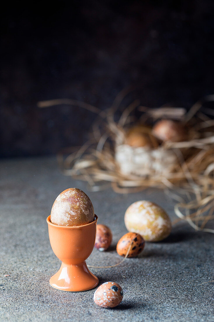 Bemalte Ostereier im Eierbecher und Nest