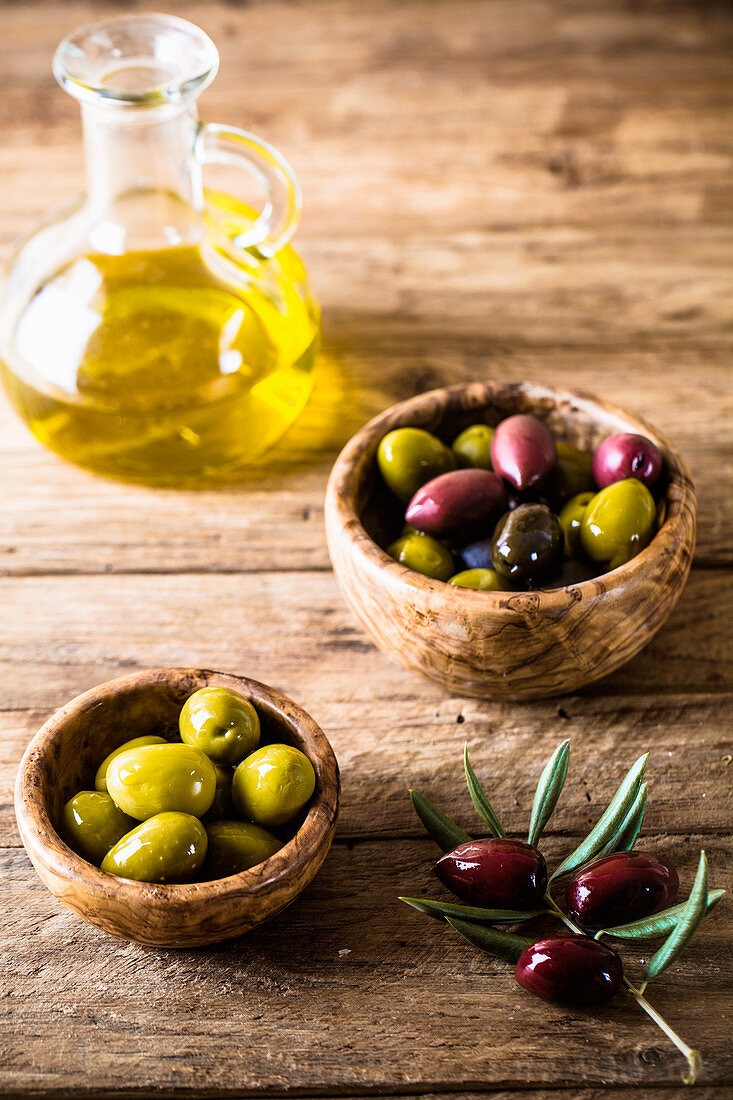 Oliven und Olivenöl auf Holztisch