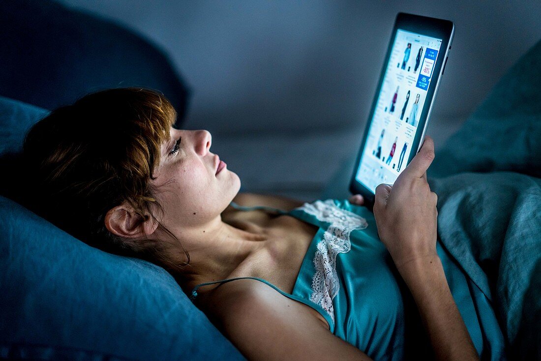 Woman using a digital tablet at night
