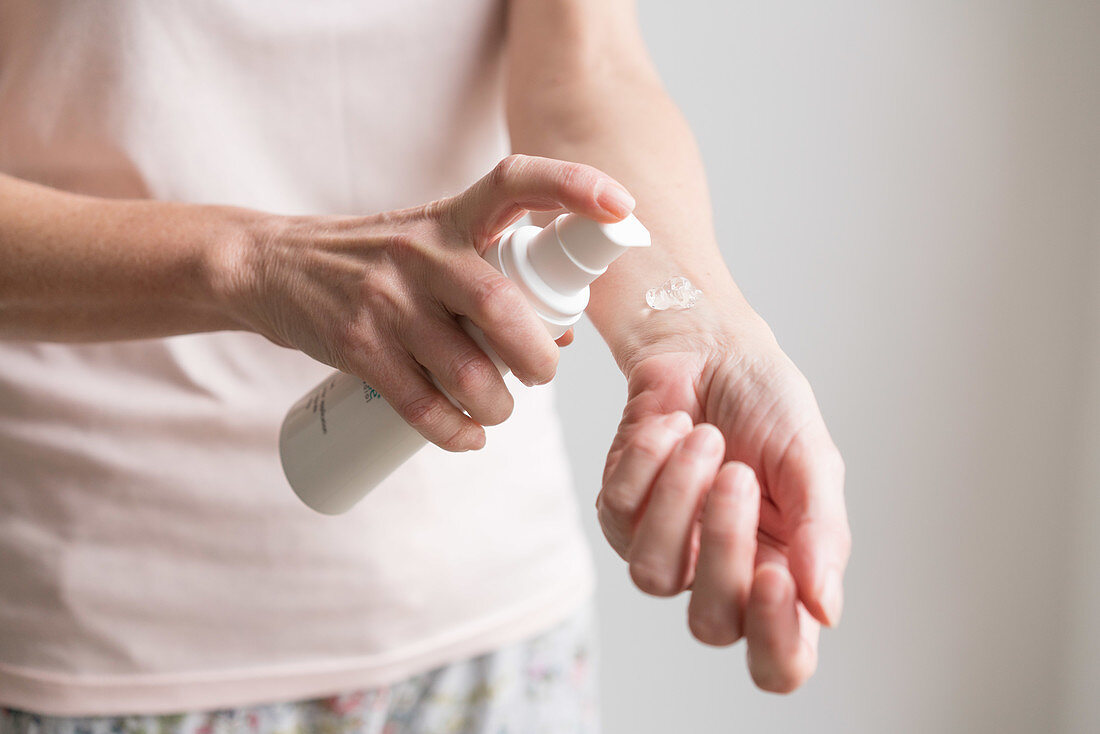 Woman applying an oestrogen gel on her hands