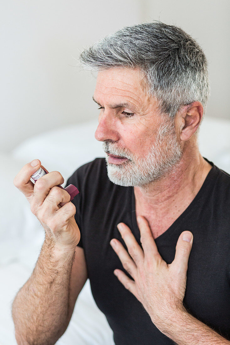Man using an inhaler during an asthma attack