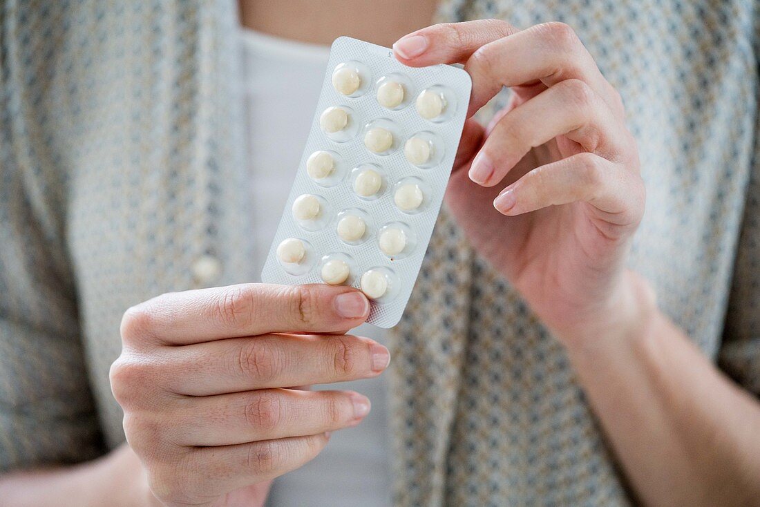 Woman taking an hormone replacement therapy pills