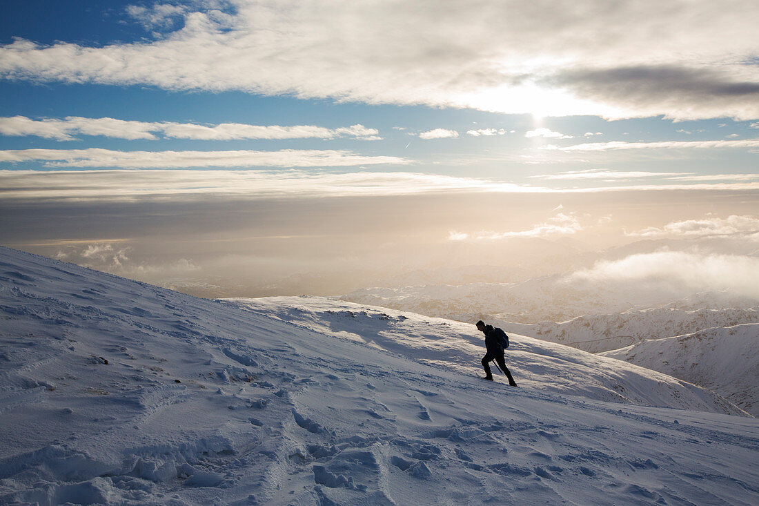 A walker ascending Dollywagon Pike in the Lake District, UK