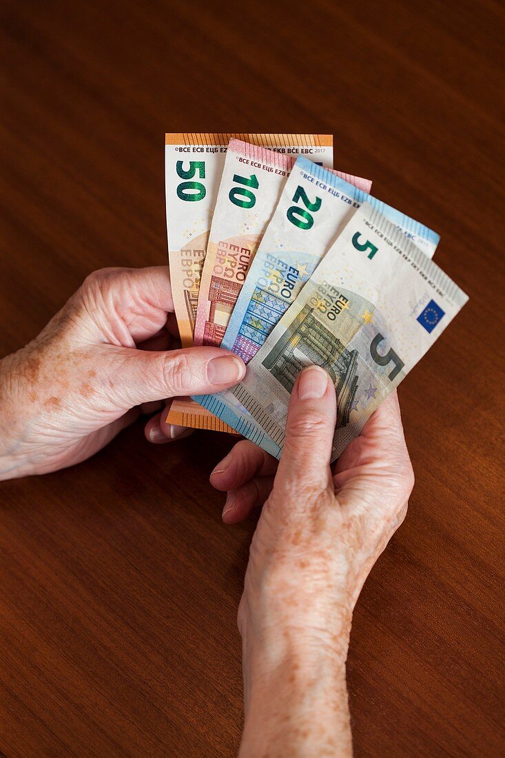 Elderly woman holding Euro banknotes