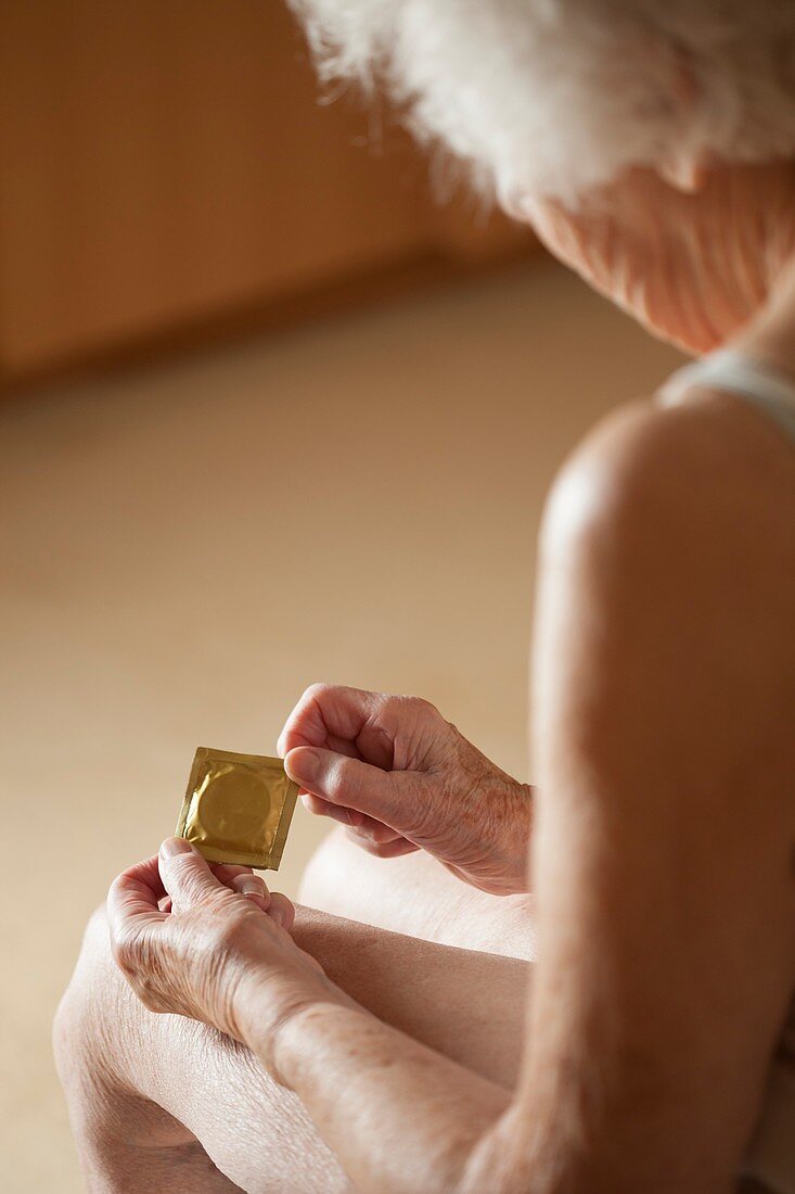 Close-up of elderly woman holding condom