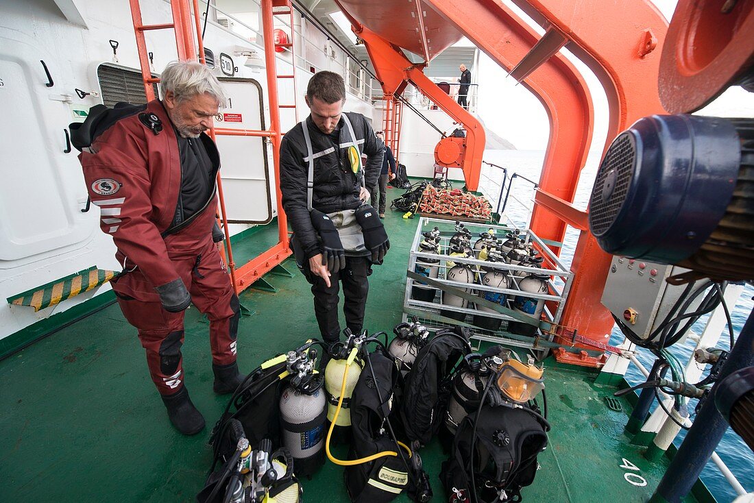 Divers preparing equipment on board ship, Greenland