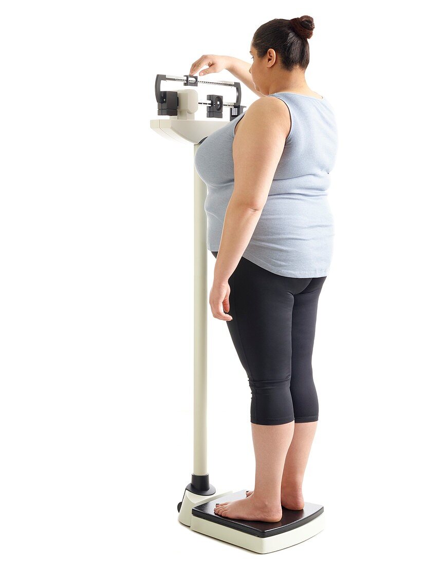 Overweight woman standing on weighing scales