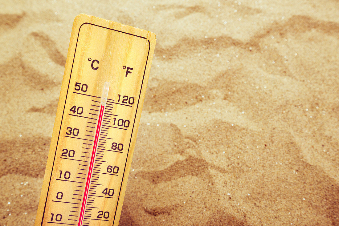 Thermometer on hot desert sand
