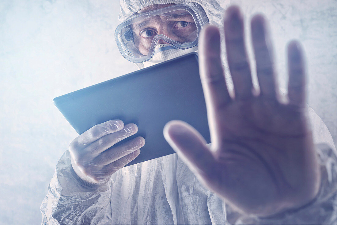 Scientist in protective suit with digital tablet