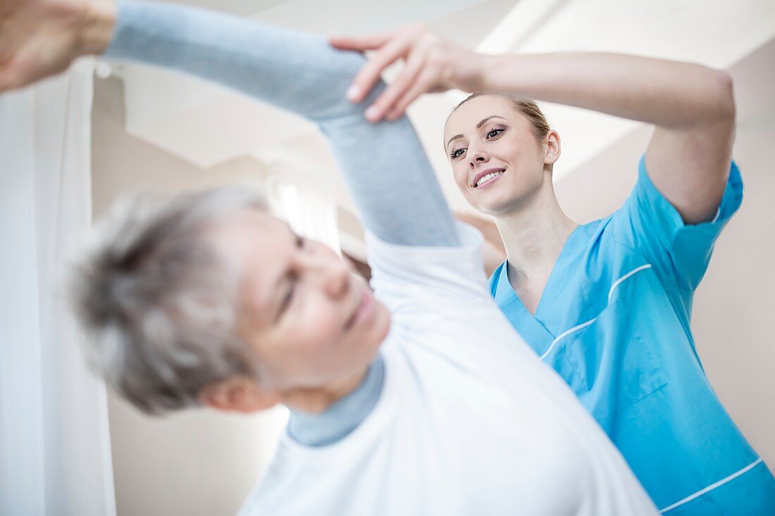 Woman stretching with physiotherapist