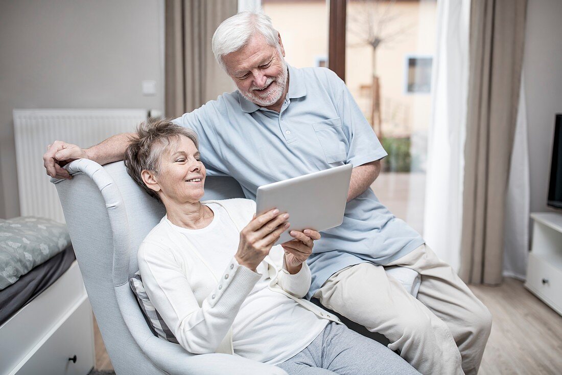 Senior couple in hospital room with tablet