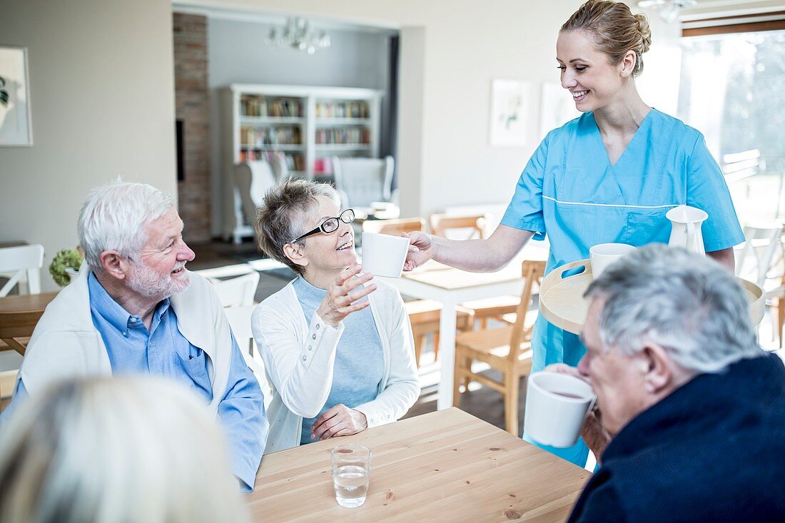 Carer serving tea to Woman