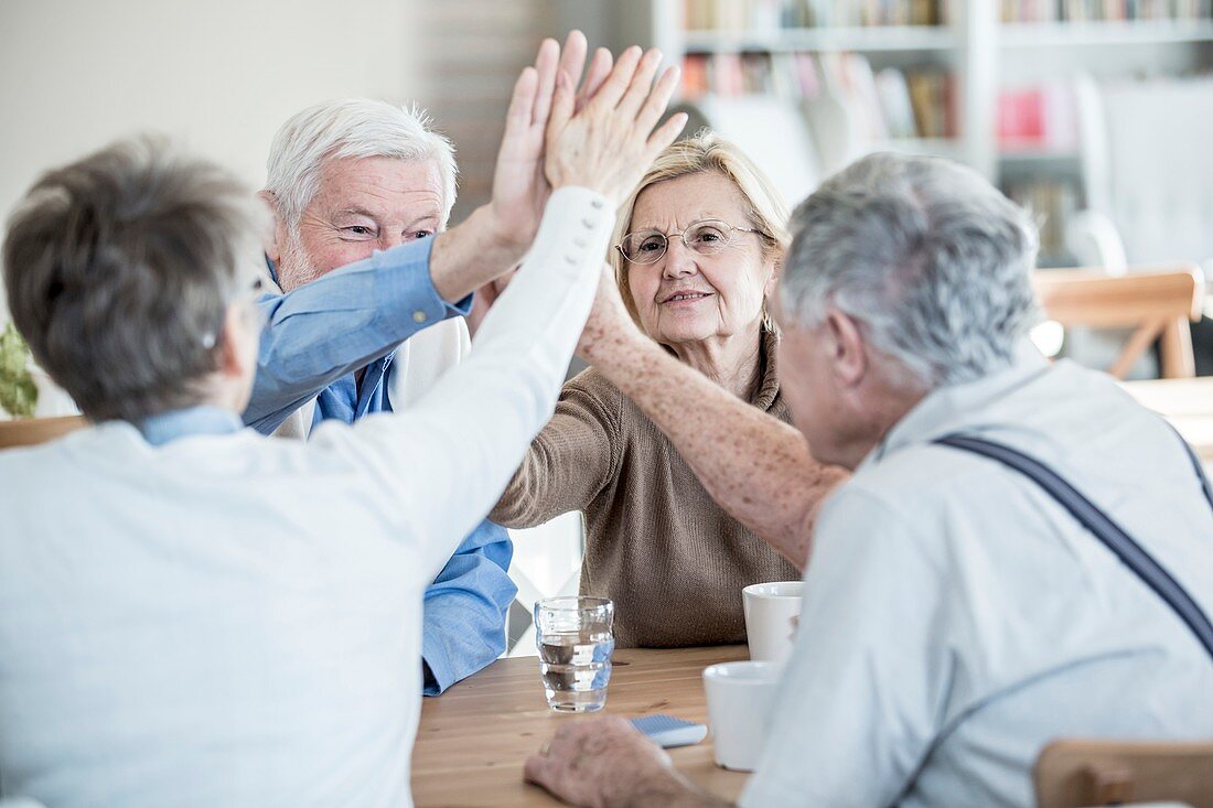 Friends giving high fives in retirement home