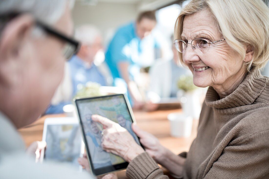 Seniors looking at photos on tablet