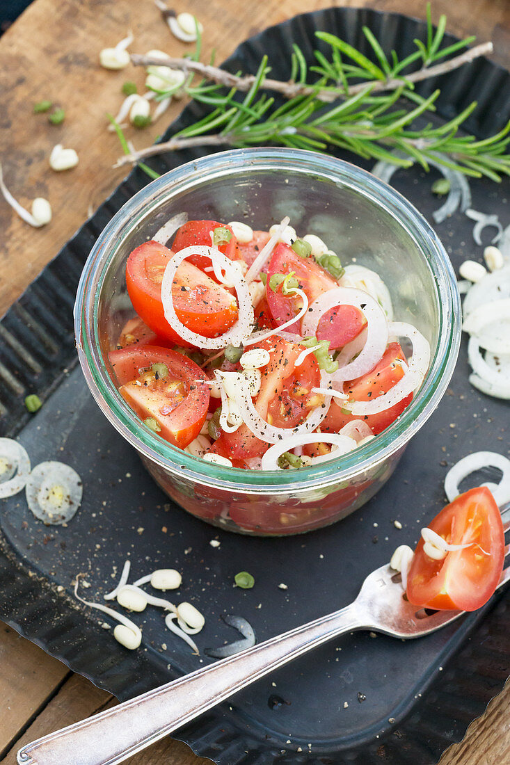 Tomato salad with onion rings and bean sprouts in a jar