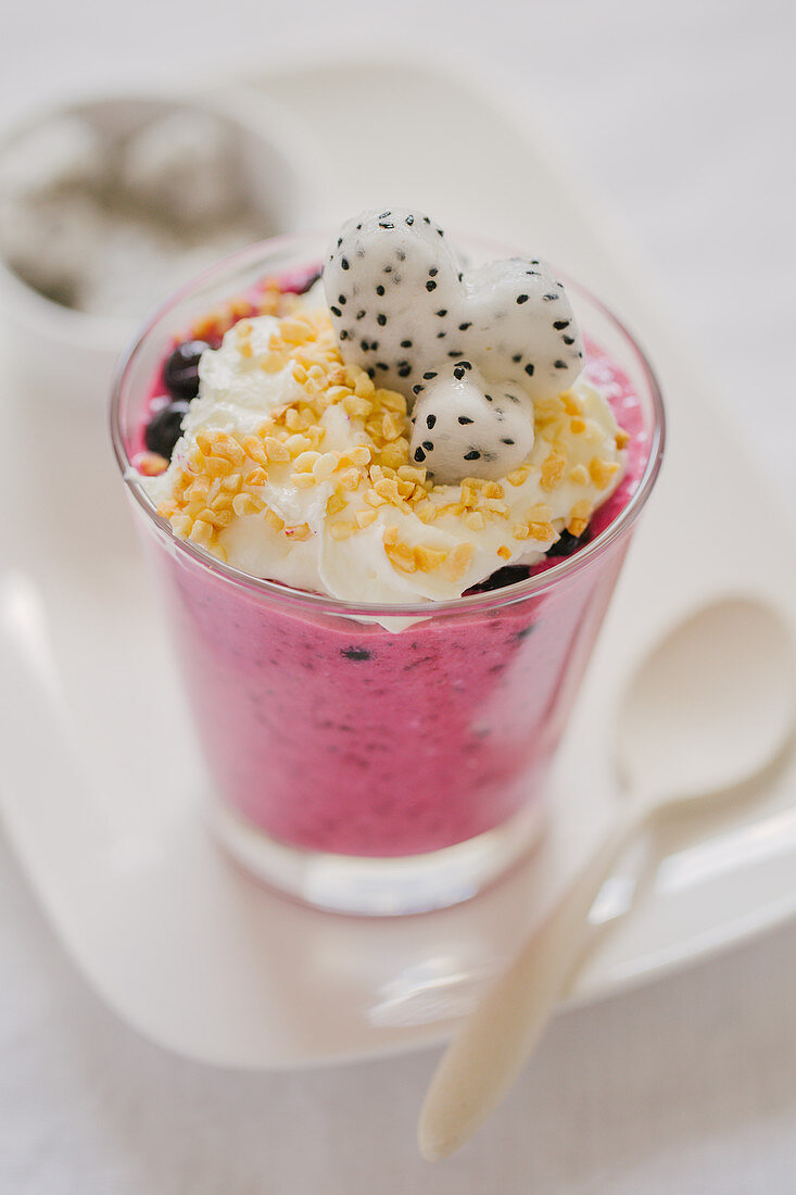 Pudding with wild berries, whipped cream, nuts and dragon fruit