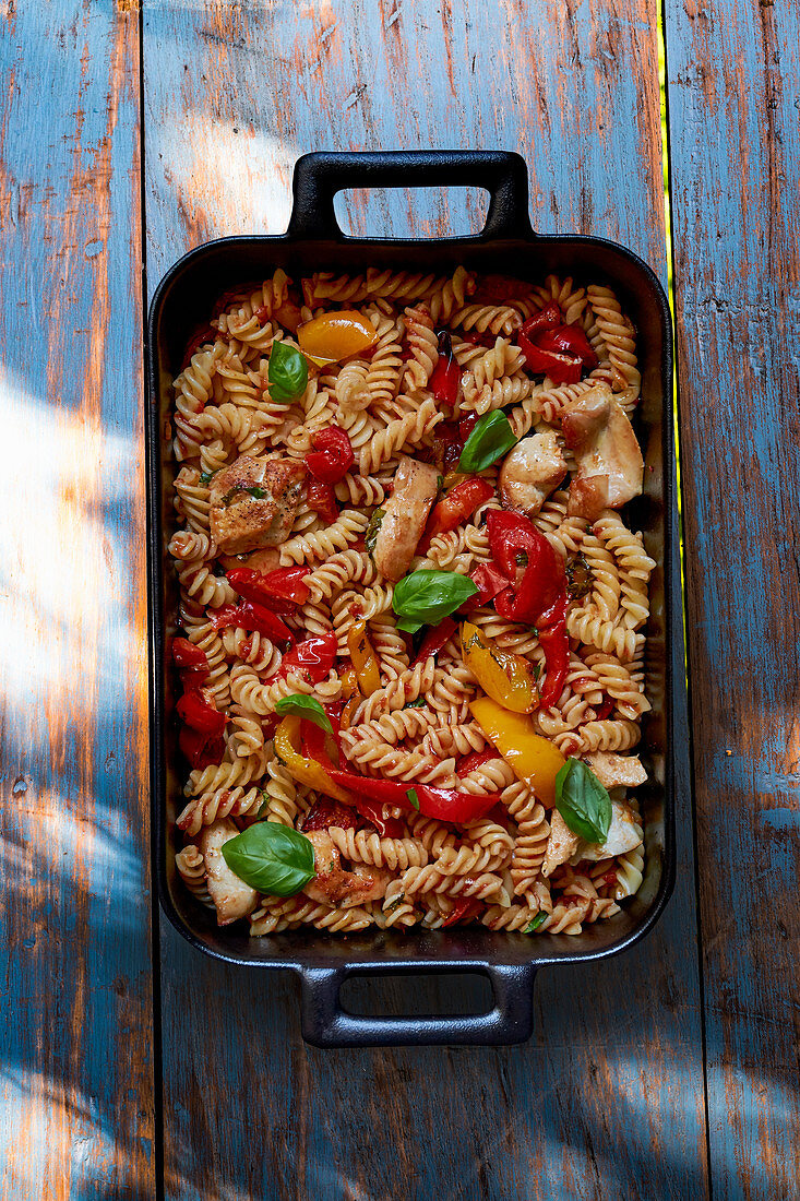 Fusilli with chicken, pepper and basil in a baking dish (seen from above)