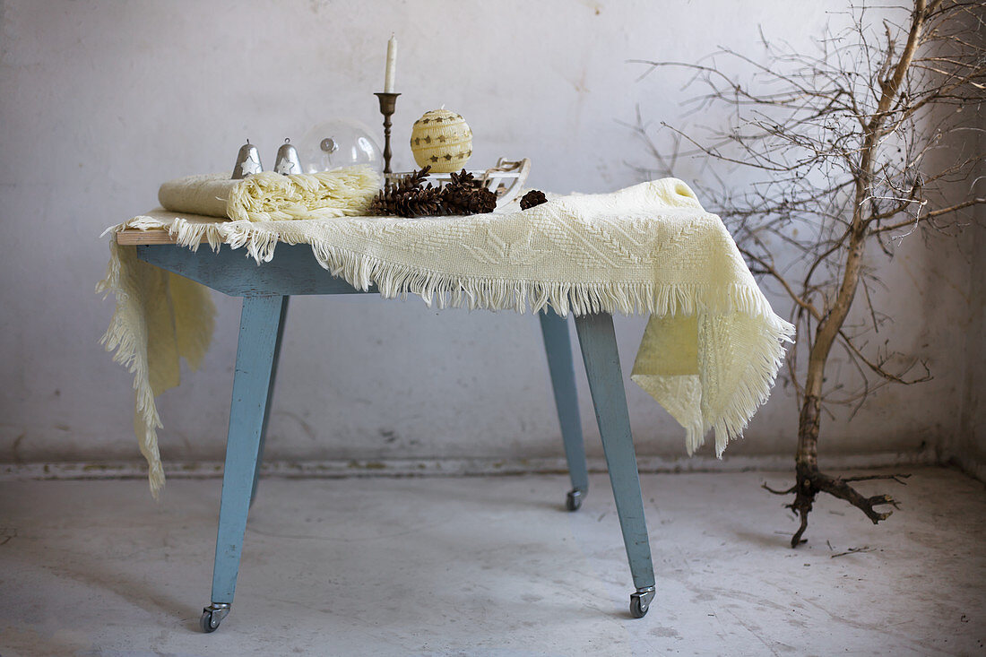 Wolldecken und Winterdeko auf einem blauen Holztisch