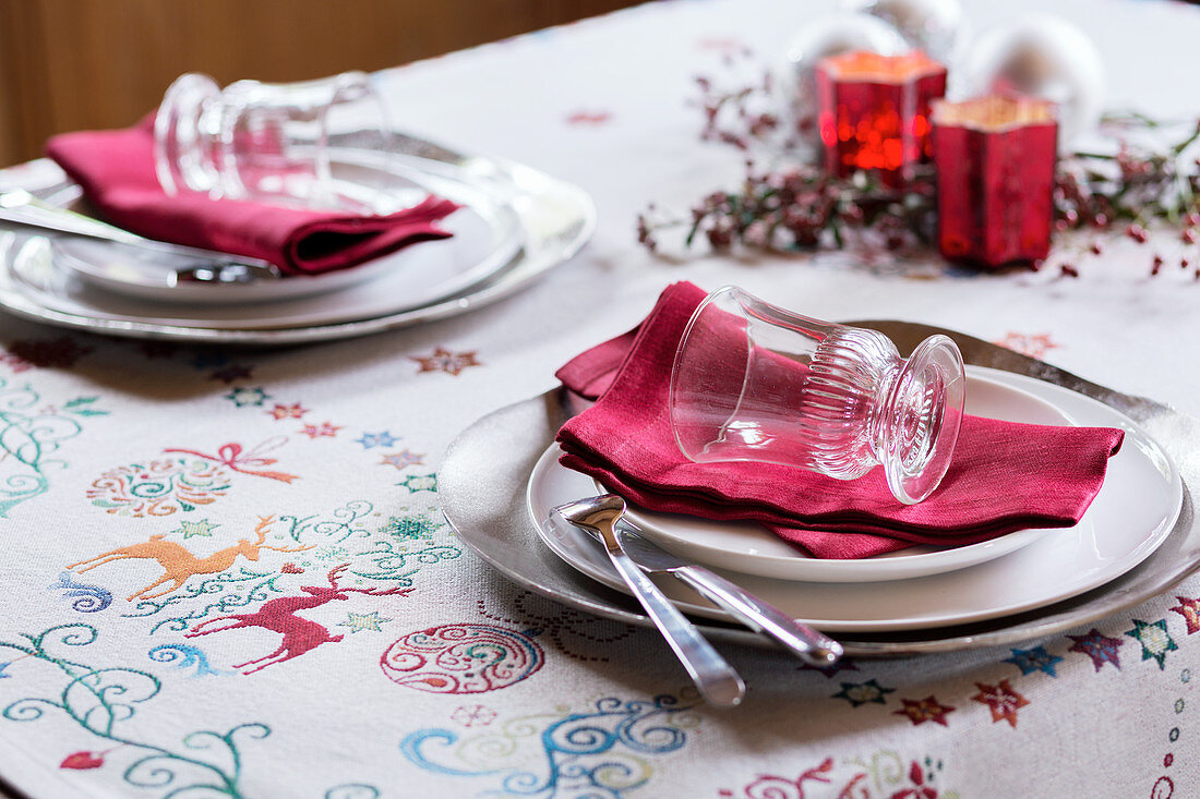 Gedeck mit roter Serviette auf weihnachtlicher Tischdecke