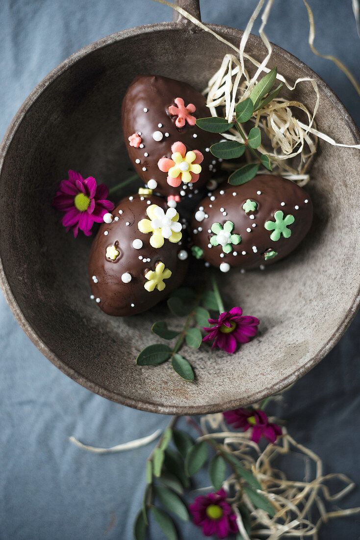 Vegane Küchlein in Ostereierform mit Zartbitterkuvertüre und Zuckerblumen