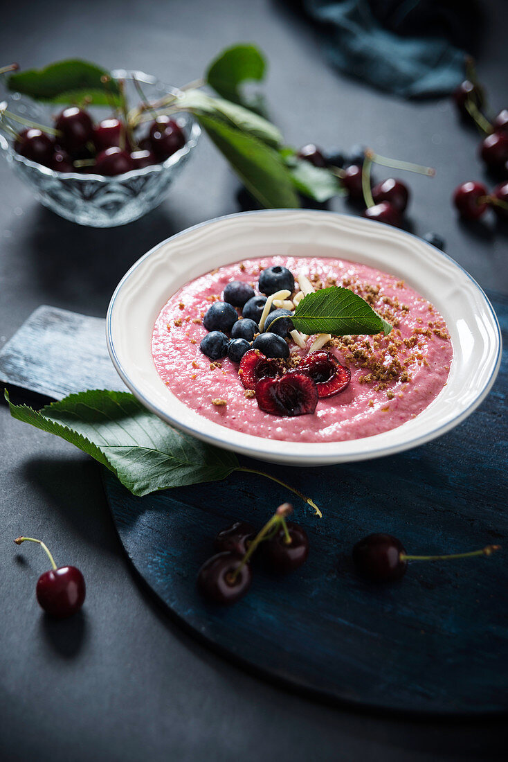 A vegan smoothie bowl with spelt, blueberries, cherries, almonds and rye breadcrumbs