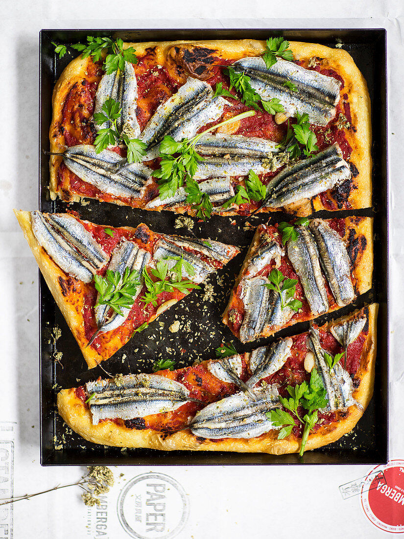 Pizza mit Tomatensauce und frischen Sardinen