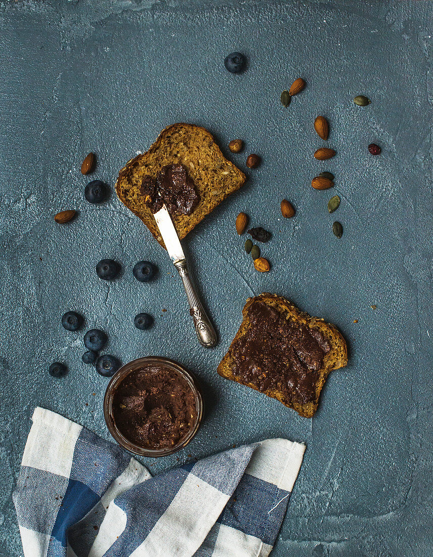 Whole grain bread toasts with organic vegan chocolate peanut butter, blueberry and nuts