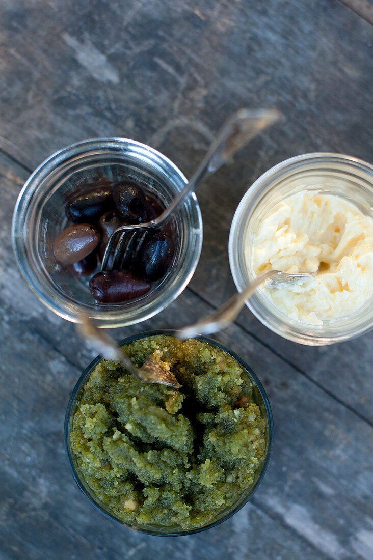 Oliven und zwei Dips in Gläsern