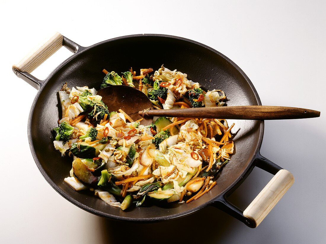 A Vegetable Stir Fry in a Wok with a Wooden Spoon